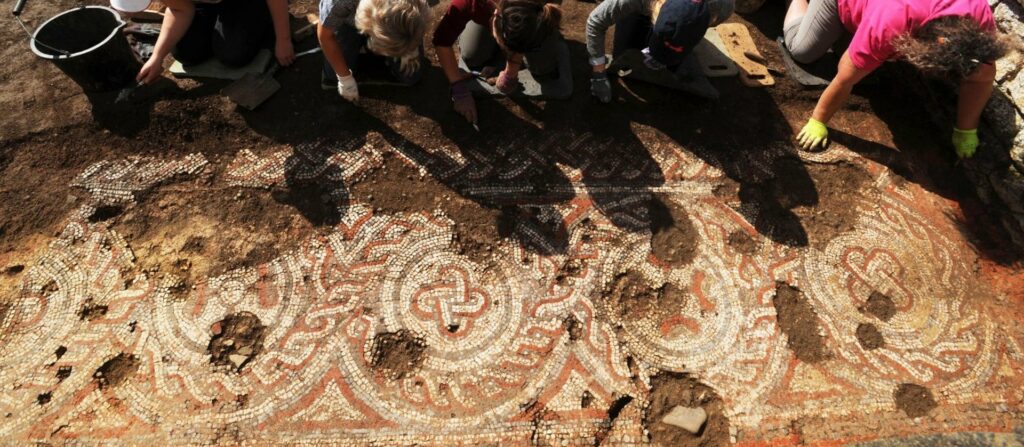 Freiwillige legen das Mosaik der Chedworth Villa frei