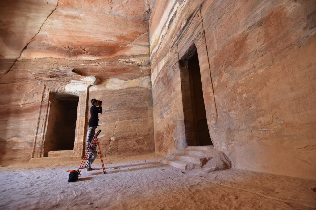 Das Bild zeigt die fotografische Dokumentation von Wandmalereien und Putzresten im Mausoleum Al-Khazne in Petra.