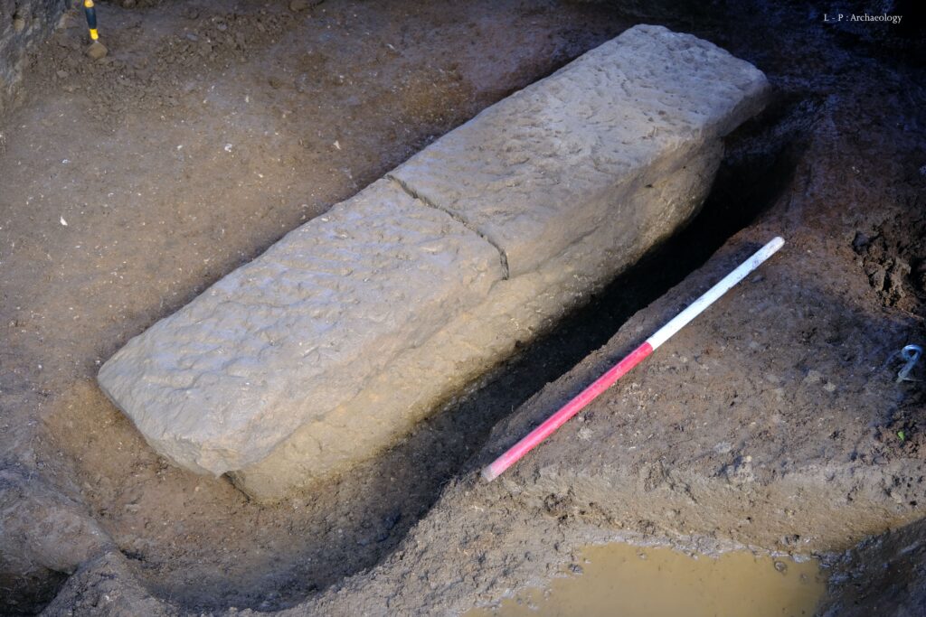 Foto des freigelegten Steinsarkophags aus Bath.
Der schmale Sarkophag ist mit zwei gleichgroßen Platten abgedeckt. Auf dem Foto sind diese noch nicht entfernt. 