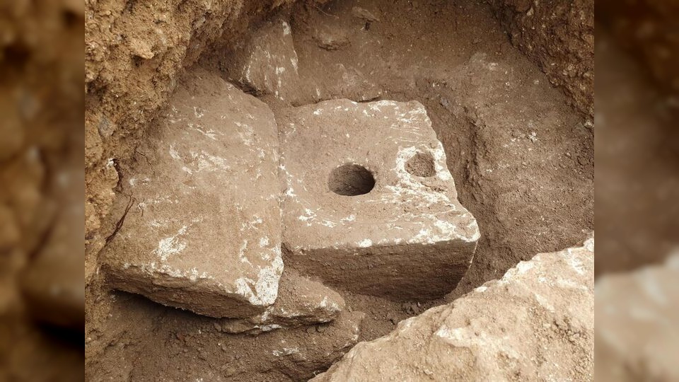 Bild der Toilette, die aus einem rechteckigen Steinblock besteht, in dessen Mitte sich eine runde Öffnung befindet.