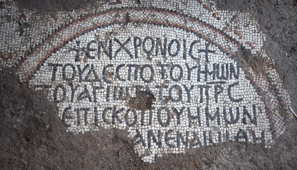 Das Bild zeigt eines der entdeckten Mosaik in Bethsaida. Die Inschrift in griechischen Buchstaben wird von einem Kreis eingefasst, der aber nur zur Hälfte erhalten ist.