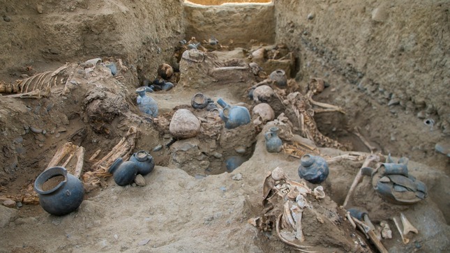 Das Bild zeigt die freigelegten Gräber in Chan Chan. Neben den Skeletten befindet sich jeweils eine Auswahl an Keramikgefäßen unterschiedlichster Form und Ausführung.