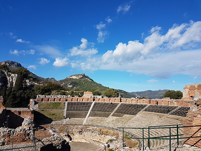 Das Bild zeigt die Sitzreihen und einen Teil der Orchestra des antiken Theaters von Taormina.