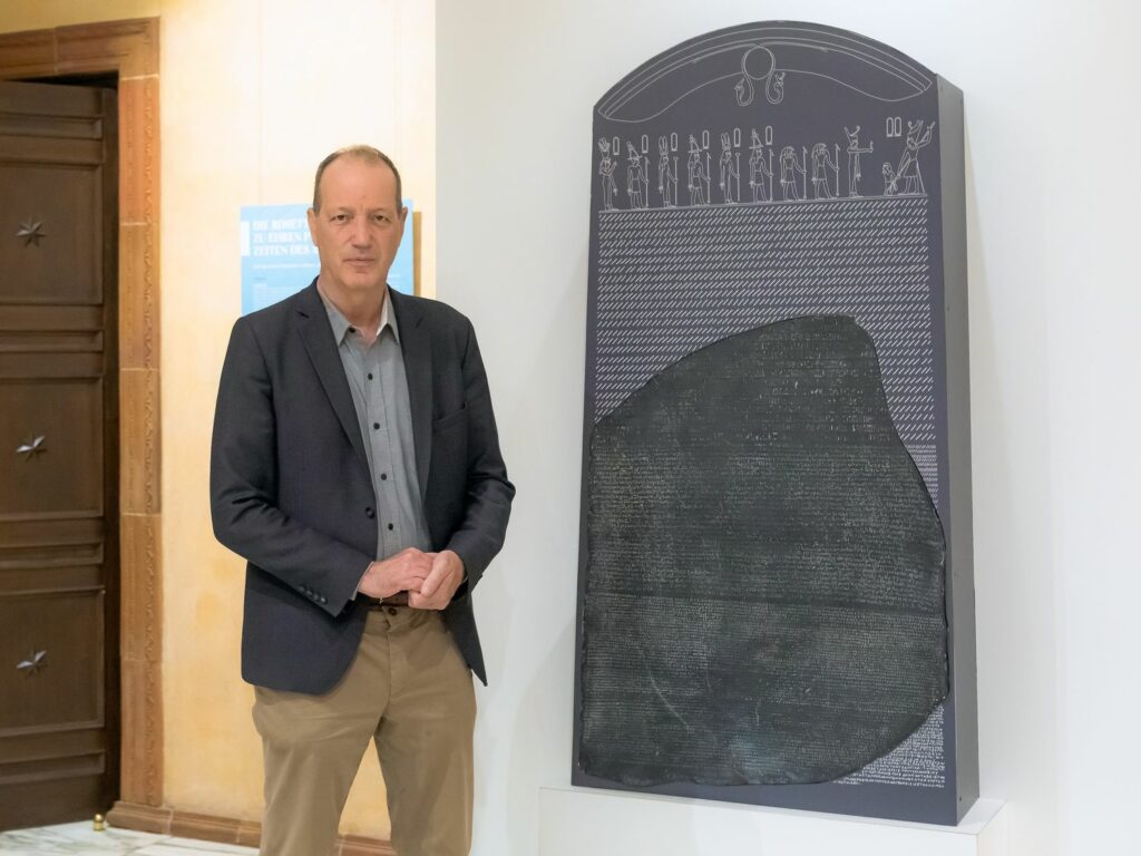 Dr. Dietrich Raue vor der Kopie des berühmten Rosetta-Steins, die in der neuen Sonderausstellung zu sehen ist.