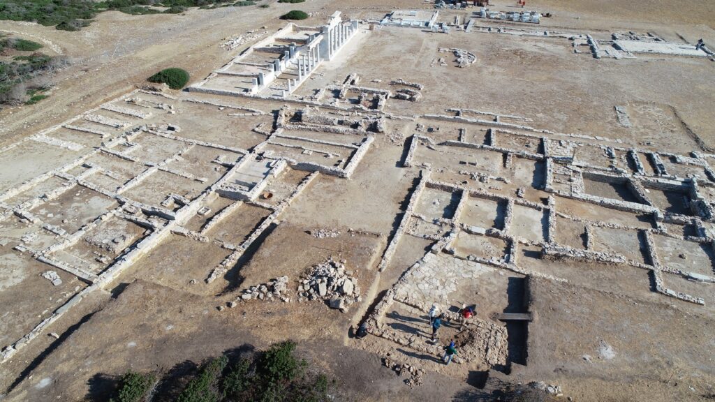 Zu sehen ist die Ausgrabungsstätte Mandra auf Despotiko mit Fundamentresten und einer rekonstruierten Säulenstellung
