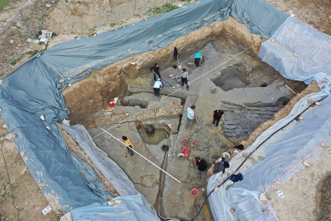 Luftbild von der Ausgrabung: Archäologinnen und Archäologen führen Vermessungs- und Grabungsarbeiten durch