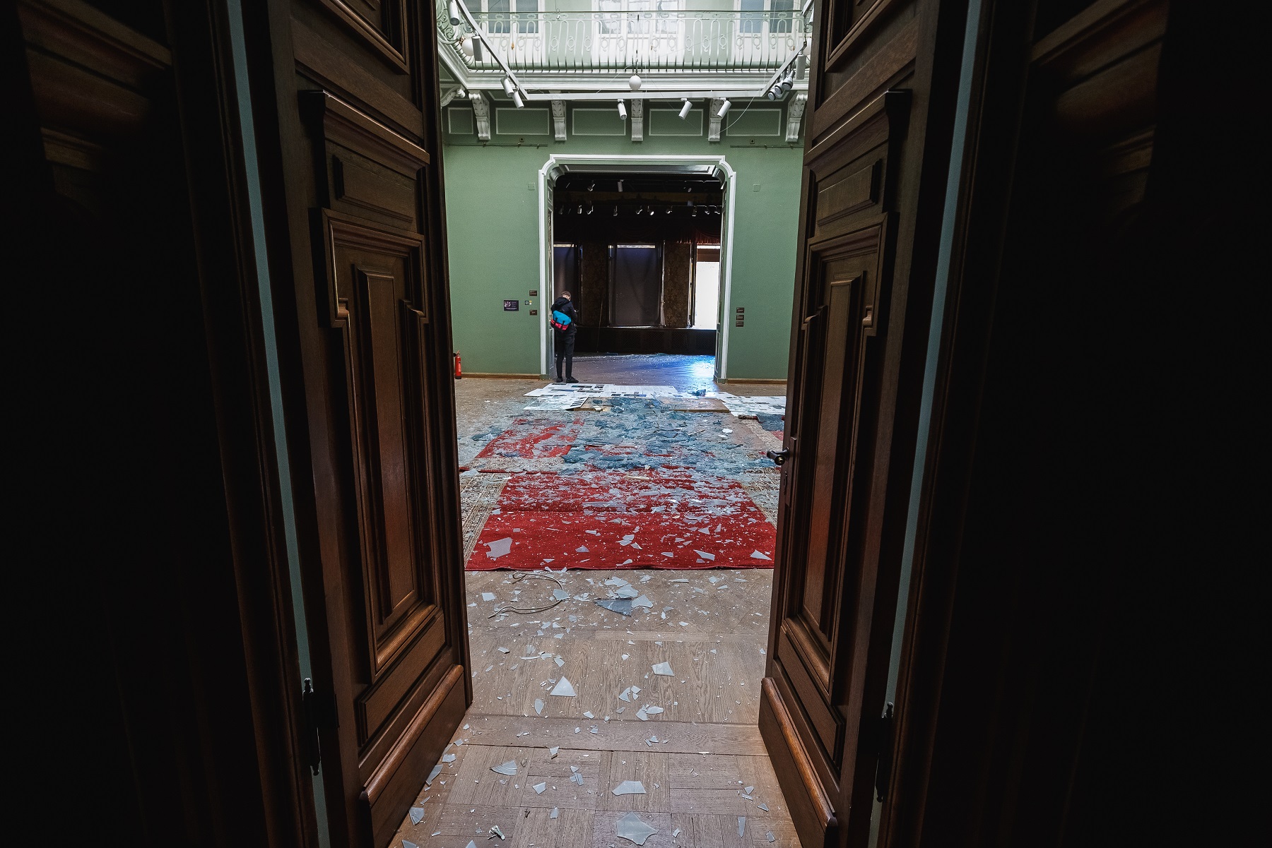 Eingangshalle des Khanenko Museums: Blick durch eine Holztür in einen Raum mit Glasscherben auf dem Boden.