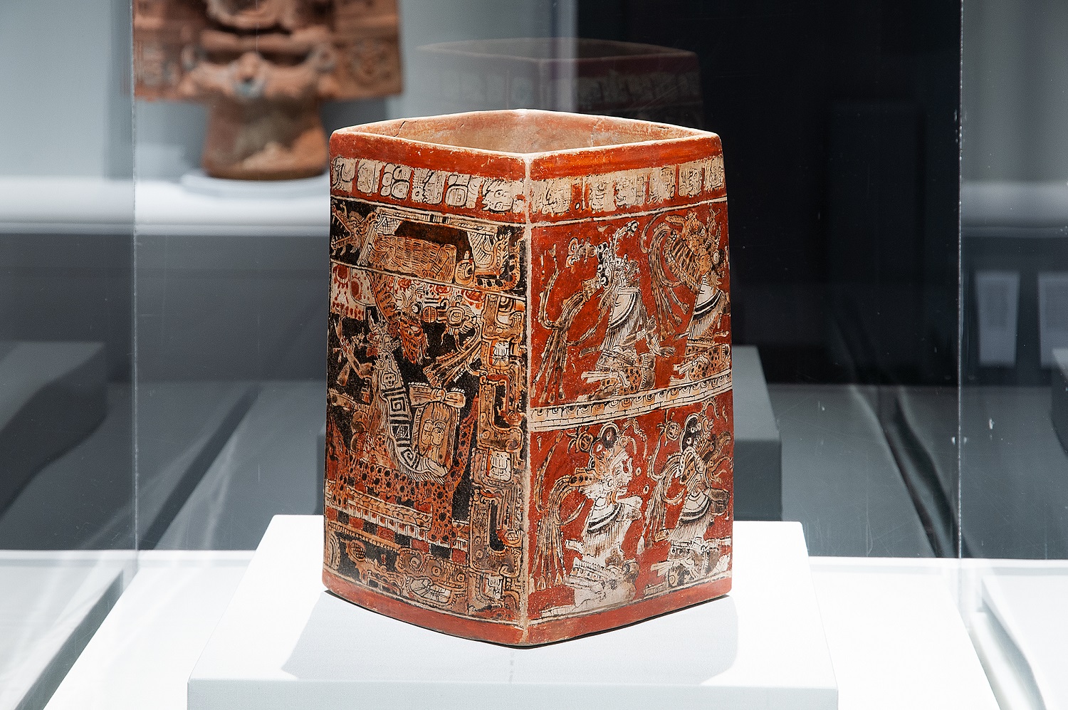 Eine Vitrine in der Ausstellung Lives of the Gods – Divinity in Maya Art im Metropolitan Museum New York, in der ein viereckiges bemaltes Gefäß steht.