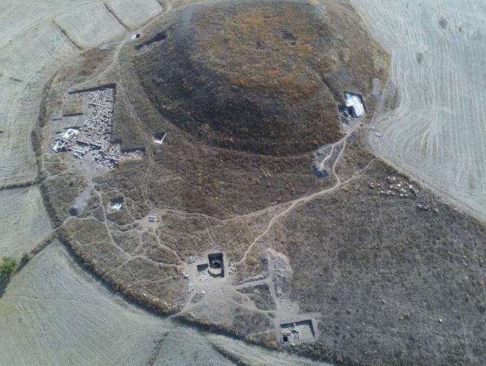 Luftbild der archäologischen Stätte von Uşaklı Höyük, die möglicherweise mit der hethitischen Stadt Zippalanda identisch ist. Am Fuß eines Hügels sind mehrere archäologische Schnitte zu sehen.